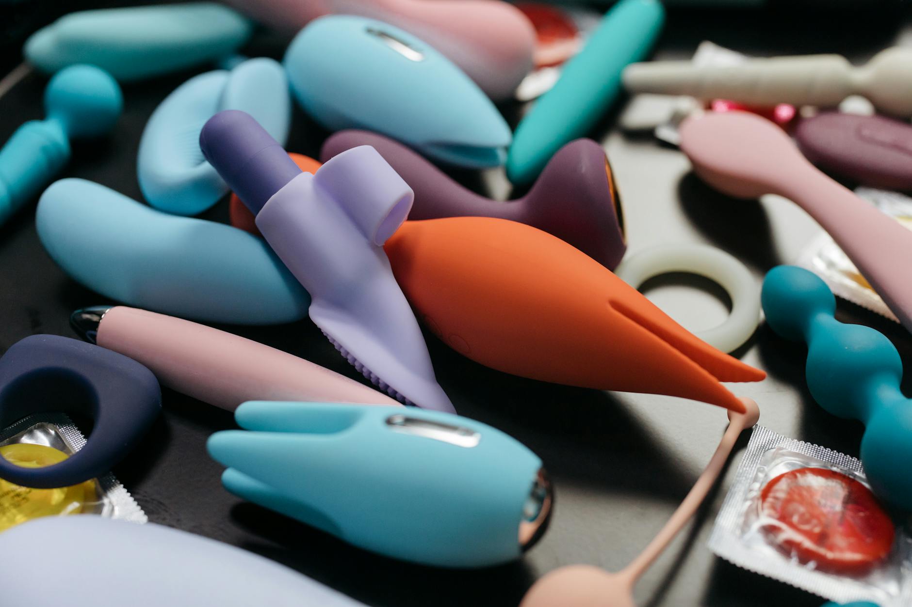 A collection of colorful personal vibrators including lemon-shaped clitoral toys displayed against a neutral background